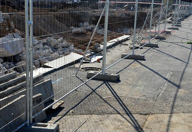 a white temporary fence used to control and direct pedestrian traffic during events